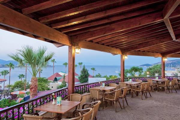 Außenterrasse des Selectum Colours Bodrum mit Blick auf das Meer und Palmen.
