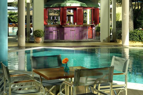Poolbereich des Dionysos Hotels mit Bar und Tischen am Pool