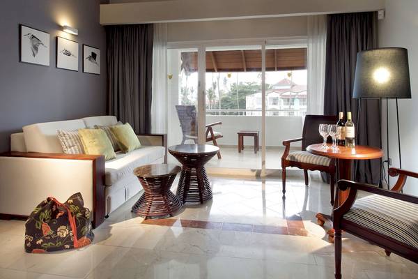 Innenansicht des Wohnbereichs des TRS Turquesa Hotels mit Couch, Tisch und Zugang zur Terrasse.