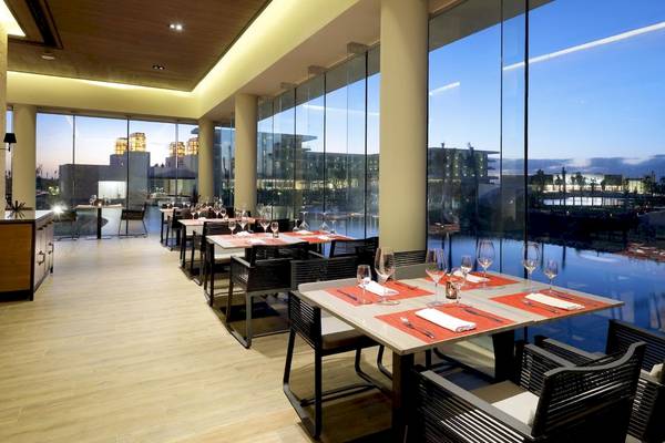 Innenansicht des Restaurants im TRS Turquesa Hotel mit modernen Möbeln und großen Fenstern.