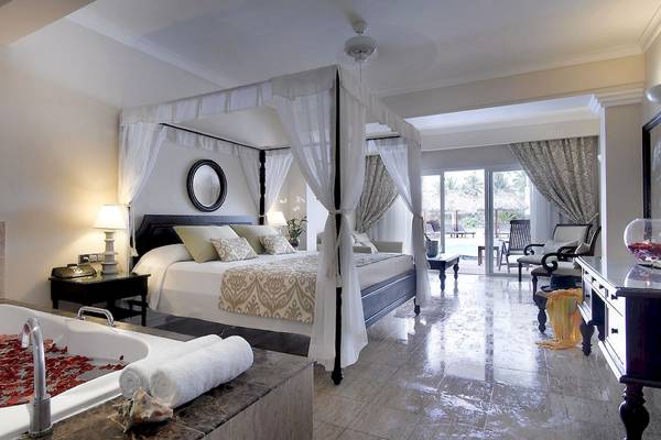 Schlafzimmer im TRS Turquesa Hotel mit einem Baldachin-Bett, einer Badewanne und einem großen Fenster.