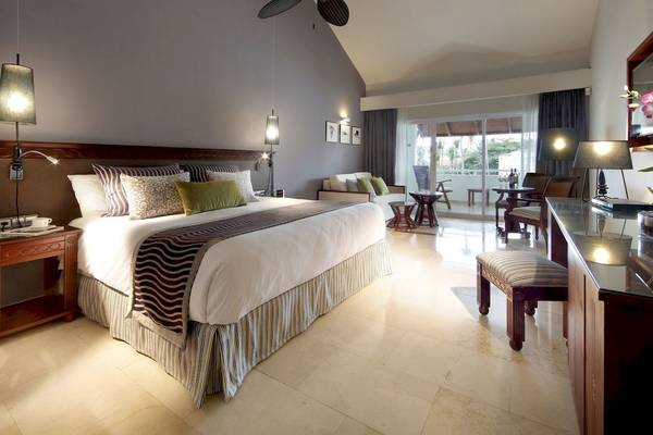 Schlafzimmer im TRS Turquesa Hotel mit großem Bett, Kissen, Tischlampen und einem Balkon
