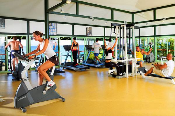 Fitnessstudio im Hotel Marti Myra mit mehreren Personen, die auf verschiedenen Geräten trainieren.