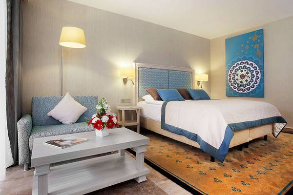 Schlafzimmer im Marti Myra Hotel mit einem Bett, einem Sofa, einem Tisch und einer Lampe.