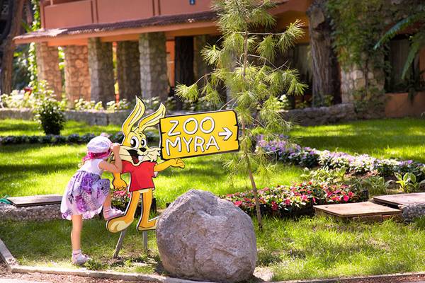 Ein kleines Mädchen berührt ein Zoo Myra Schild vor dem Marti Myra Hotel.