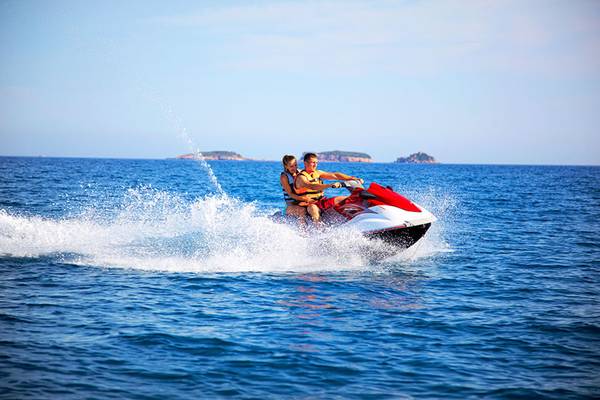 Zwei Leute fahren auf einem Jet Ski im Meer und genießen die Fahrt.