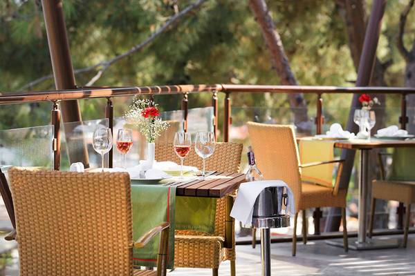 Terrasse mit Tisch und Stühlen im Hotel Marti Myra, gedeckt mit Wein und Blumen