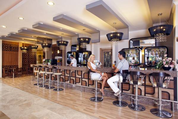 Innenansicht der Bar im Titan Select Hotel mit Gästen an der Theke und Dekor.