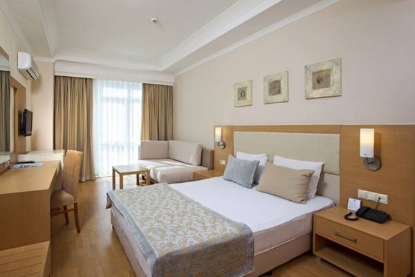 Das Zimmer im Titan Select Hotel mit einem Bett, Schreibtisch, Sofa und Bildern an der Wand.