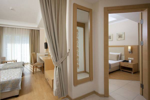 Innenansicht eines Zimmers im Titan Select Hotel mit zwei Betten, Schreibtisch und großem Spiegel.