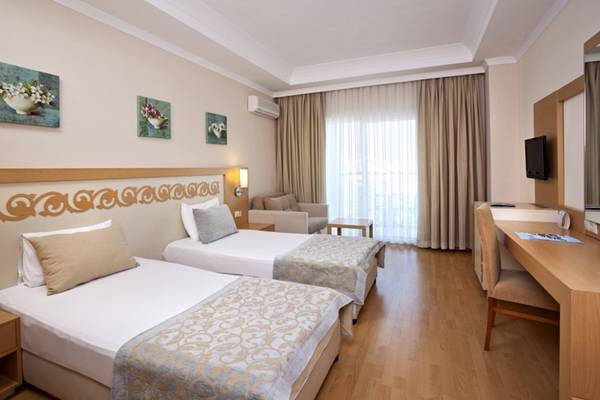 Doppelzimmer im Titan Select Hotel mit zwei Betten, Schreibtisch, Fernseher und Fenstern.