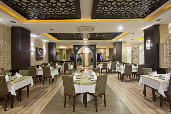 Innenbereich des Titan Select Hotels, das Restaurant mit gedeckten Tischen und dekorativen Wandverkleidungen.