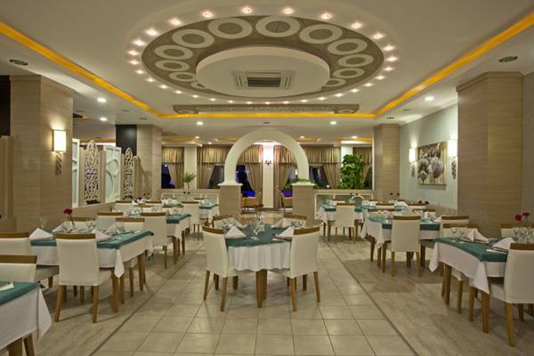 Innenbereich des Restaurants im Titan Select Hotel mit runden Deckenleuchten und gedeckten Tischen.