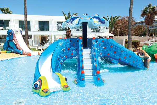 Wasserspielplatz im Dome Beach Hotel & Resort mit bunten Wasserrutschen und einer Frau im Hintergrund.