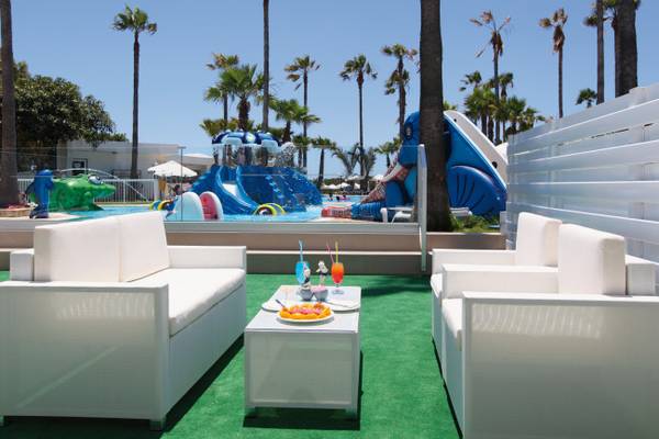 Außenbereich des Dome Beach Hotel & Resort mit Wasserrutschen und grünem Rasen