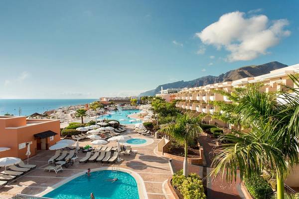Außenbereich des Landmar Costa Los Gigantes Resorts mit Swimmingpools, Sonnenliegen und Palmen