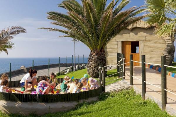 Gruppe von Kindern spielt im Sandkasten am Strand vor dem H10 Rubicon Palace