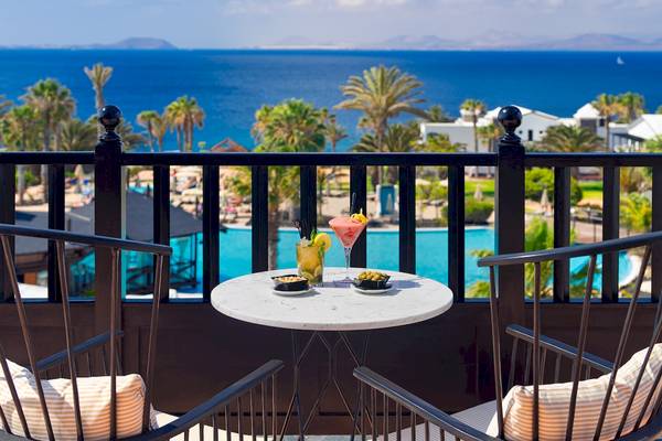 Terrasse des H10 Rubicon Palace mit Blick auf das Meer und Cocktails auf dem Tisch.
