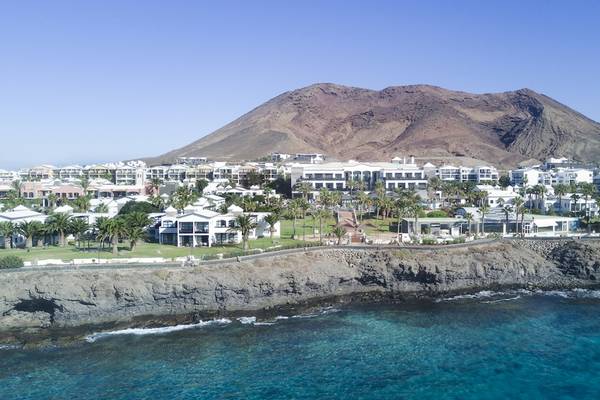 Luftaufnahme des H10 Rubicon Palace Hotels mit Berg im Hintergrund und blauem Meer
