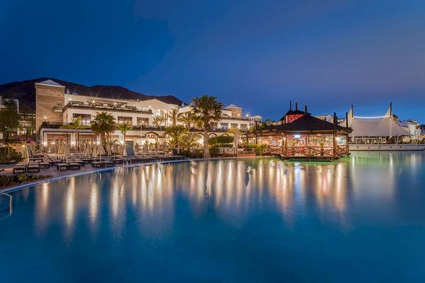 Nachtansicht des H10 Rubicon Palace mit Swimmingpool, Loungebereich und Beleuchtung.