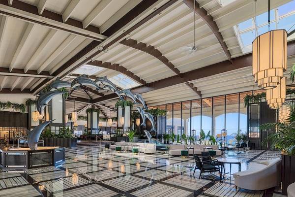 Die Lobby des H10 Rubicon Palace mit Delfinskulpturen und modernen Möbeln.