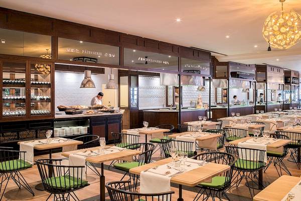 Innenansicht des Restaurants im H10 Rubicon Palace mit Tisch und Stühlen, Theken und Angestellten.