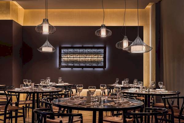 H10 Rubicon Palast Restaurant Innenraum mit Tisch und Stühlen, goldenen Lampen und Wandkunst.