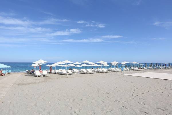 Minos Mare Royal Hotel Strand mit Sonnenschirmen und Liegestühlen