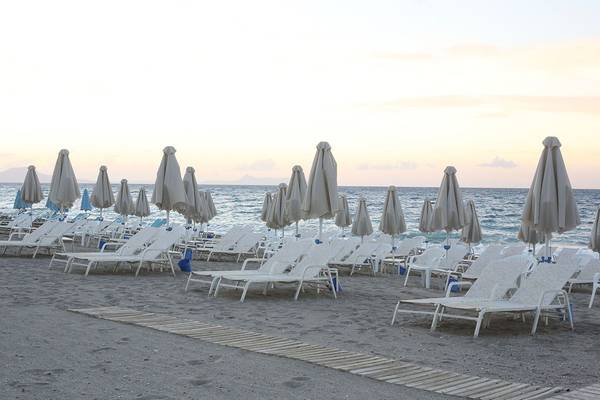 Strand mit Sonnenliegen und Sonnenschirmen am Abend