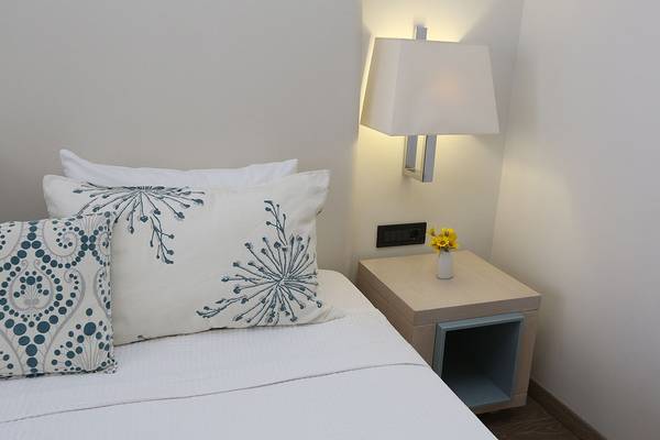 Bett mit Kissen und Nachttischlampe im Minos Mare Royal Hotel