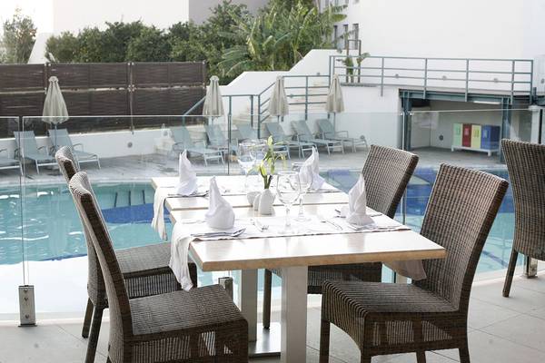 Eingerichteter Tisch im Freien neben dem Pool im Minos Mare Royal Hotel.