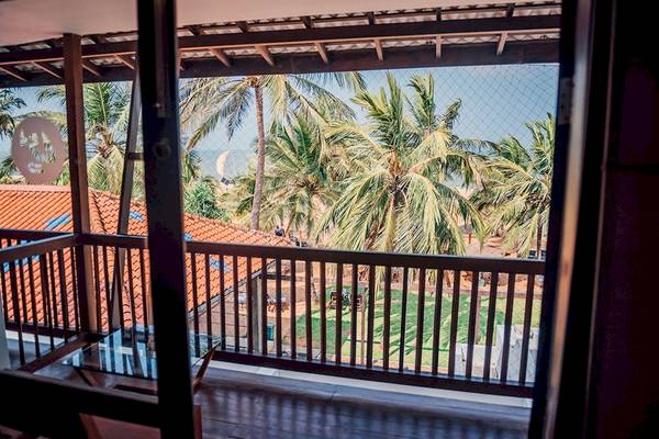 Aussicht vom Balkon des Goldi Sands Hotels auf den Strand und Palmen