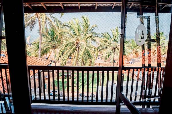 Aussicht vom Balkon des Goldi Sands Hotels auf den Strand mit Palmen und Meer.