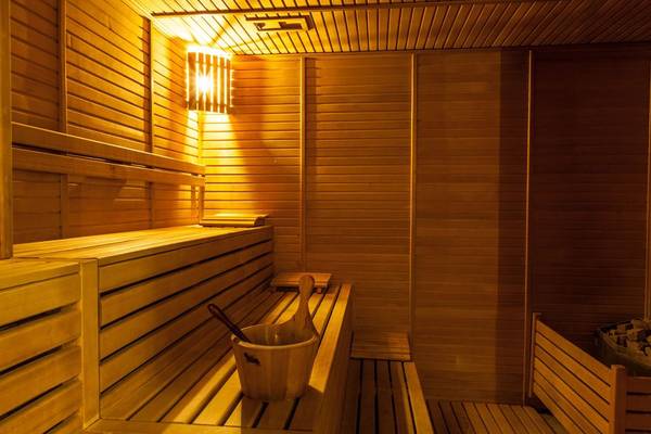Sauna im Adalya Bliss Hotel mit Holzbänken und einem Eimer auf der Bank