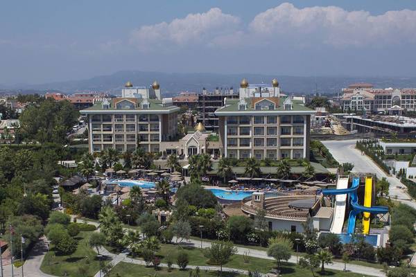 Luftaufnahme des Adalya Bliss Hotels mit Pools, Wasserrutschen und umgebenden Bäumen.
