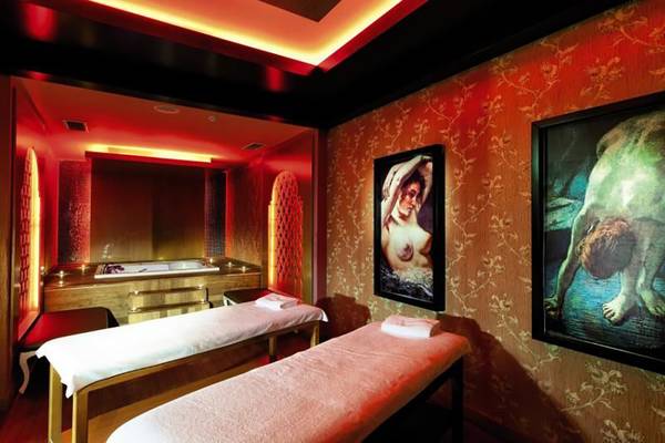 Spa-Behandlungsraum im Adalya Bliss Hotel mit zwei Massagetischen und kunstvollen Wandmalereien.