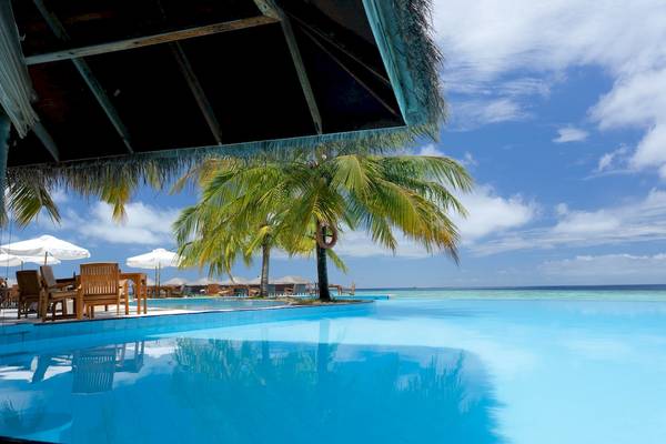 Strandpool mit Palmen am Filitheyo Island Resort mit Blick auf das Meer.