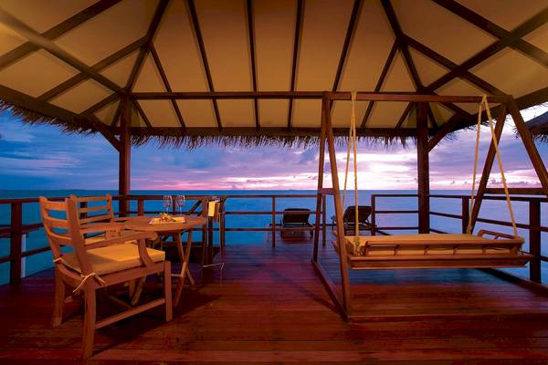 Terrasse des Filitheyo Island Resorts bei Sonnenuntergang mit Blick aufs Meer.