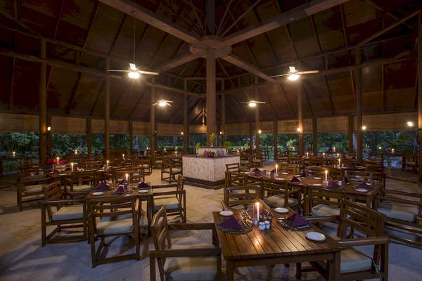Innenbereich des Restaurants im Filitheyo Island Resort mit beleuchteten Tischen und Stühlen.