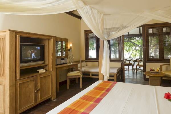 Hotelzimmer im Filitheyo Island Resort mit Bett, Fernseher, Schreibtisch und Möbeln.