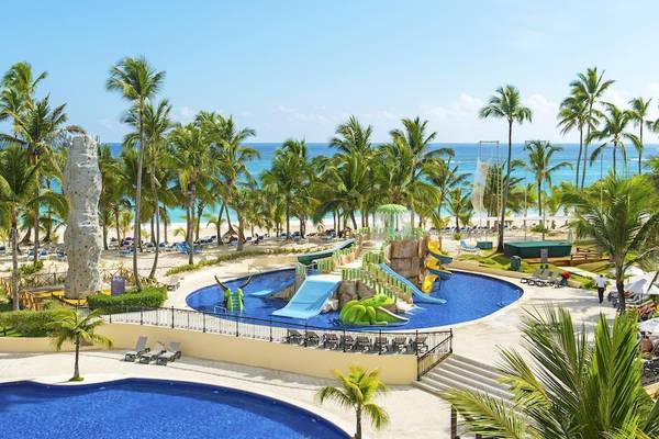 Luftaufnahme des Poolbereichs des Occidental Caribe Hotels mit Wasserrutschen und Palmen