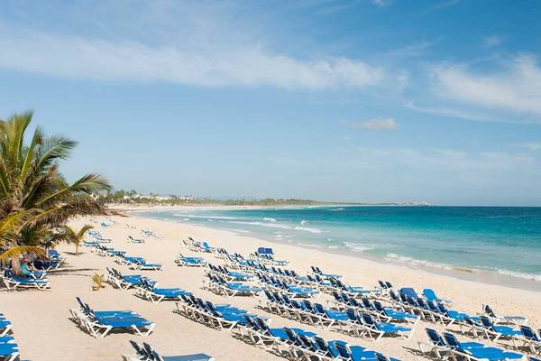Strand des Occidental Caribe Hotels mit vielen Liegestühlen und blauem Wasser