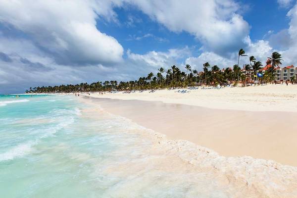 Strand mit Hotel Occidental Caribe im Hintergrund, Menschen und Palmen