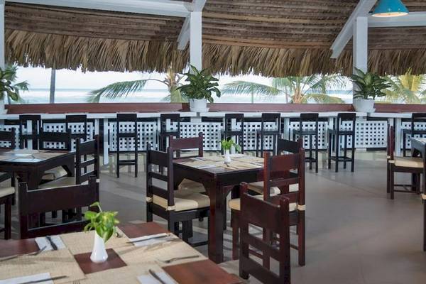 Terrasse des Occidental Caribe Hotels mit Blick auf das Meer und vielen Tischen.