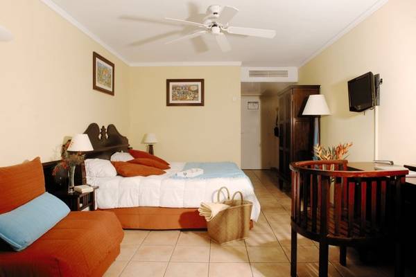 Hotelzimmer mit einem Bett, einem Sofa und einem Babybett im Pierre & Vacances Village Club Sainte-Anne.