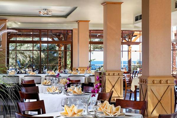 Innenansicht des Restaurants im Beach Albatros Resort mit gedeckten Tischen und Blick auf das Meer.