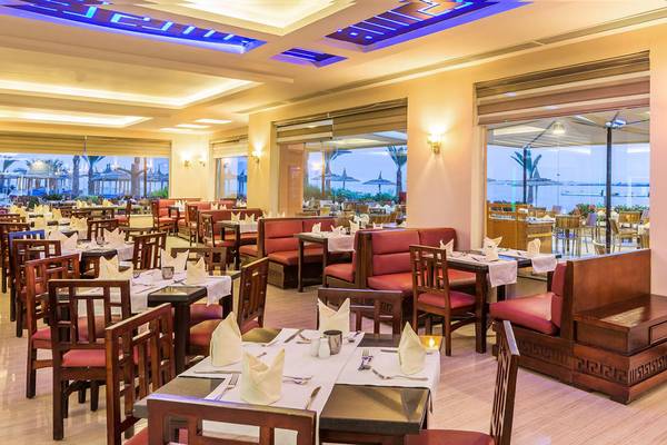 Innenansicht des Restaurants im Beach Albatros Resort mit gedeckten Tischen und Stühlen.