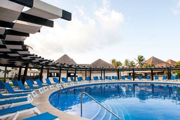 Außenpool des Allegro Playacar Hotels mit blauen Liegestühlen und Sonnenschirmen.