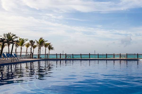 Außenpool des Allegro Playacar Hotels mit Liegestühlen und Blick auf das Meer