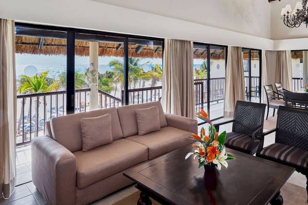 Wohnbereich des Allegro Playacar Hotels mit Blick auf das Meer und Palmen.
